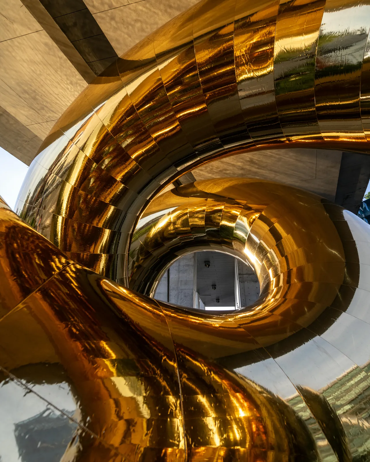 Primer plano de las espirales doradas y pulidas como un espejo de la instalación Bulgari Serpenti