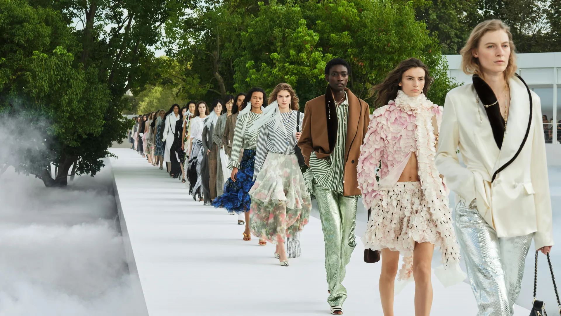 Final del desfile femenino Dior Summer 2027: modelos en una pasarela blanca entre árboles y niebla