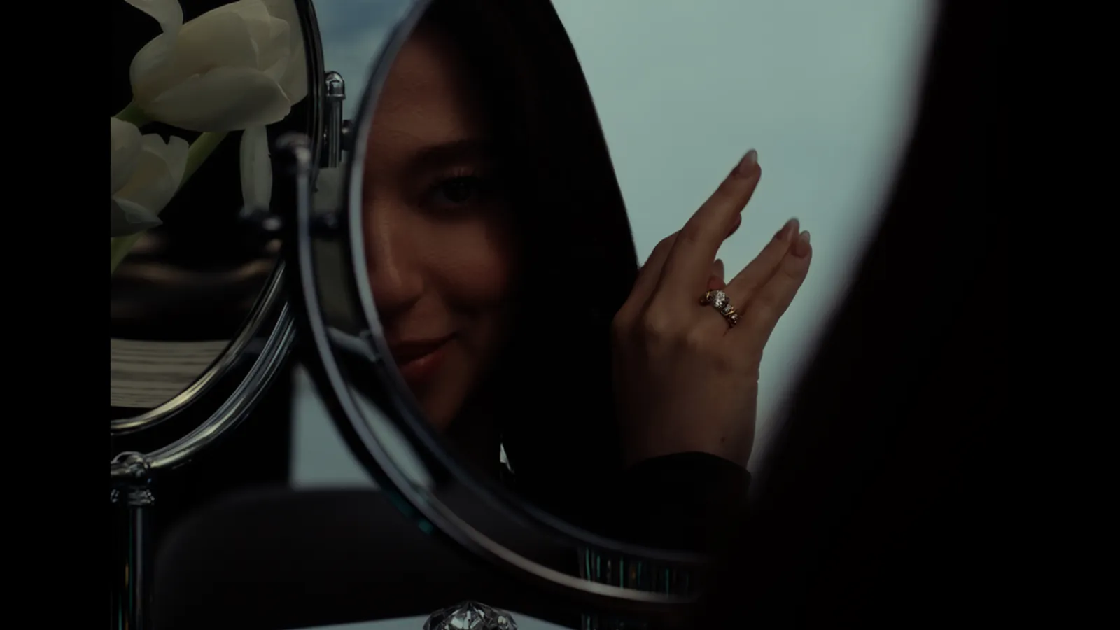 Fotograma de la película de Tiffany & Co.: Mikey Madison reflejada en un espejo, con el anillo Sixteen Stone by Tiffany